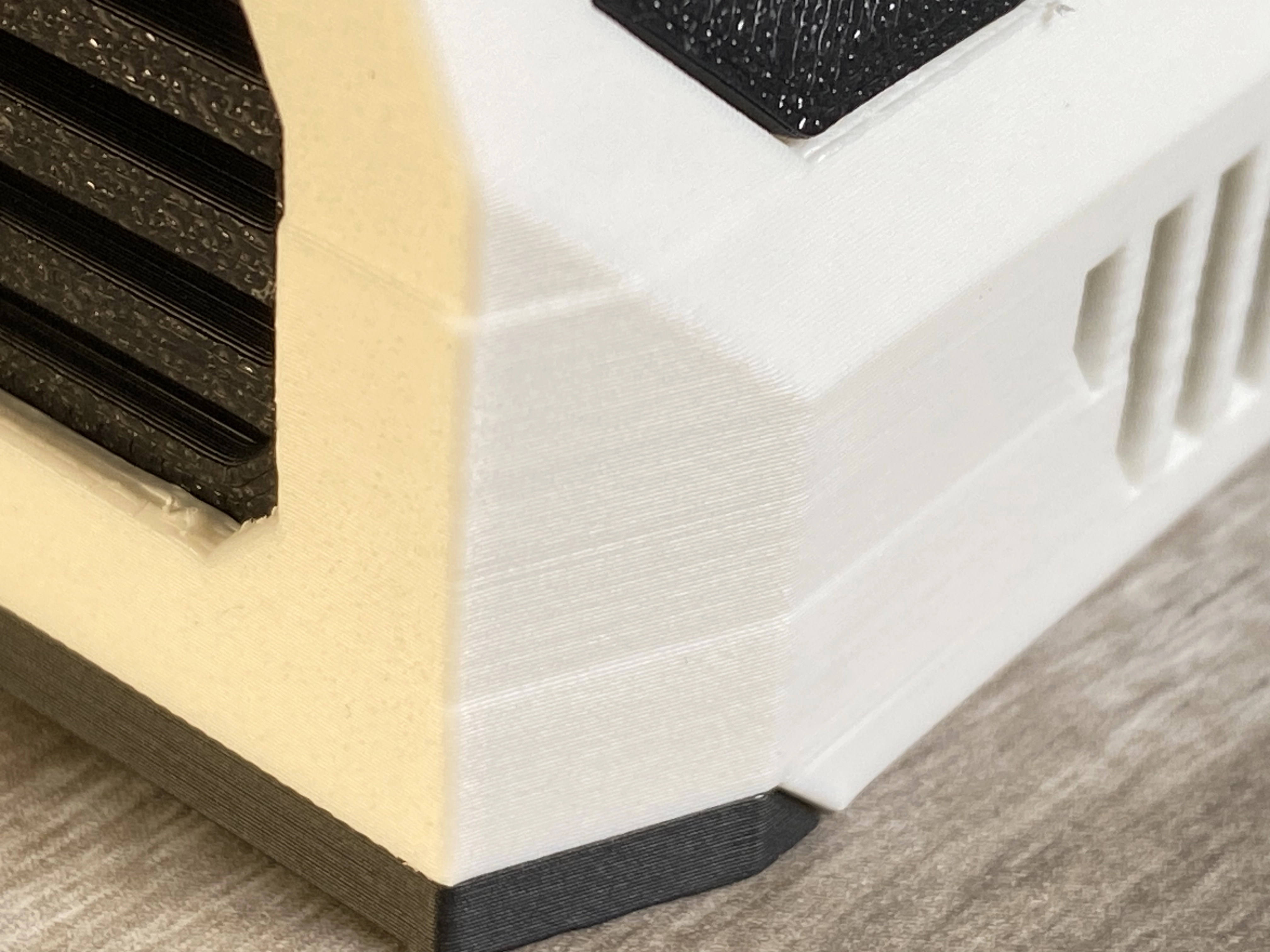 Close-up of an Aura case corner showing faint 3D-print layer lines and a small surface blemish